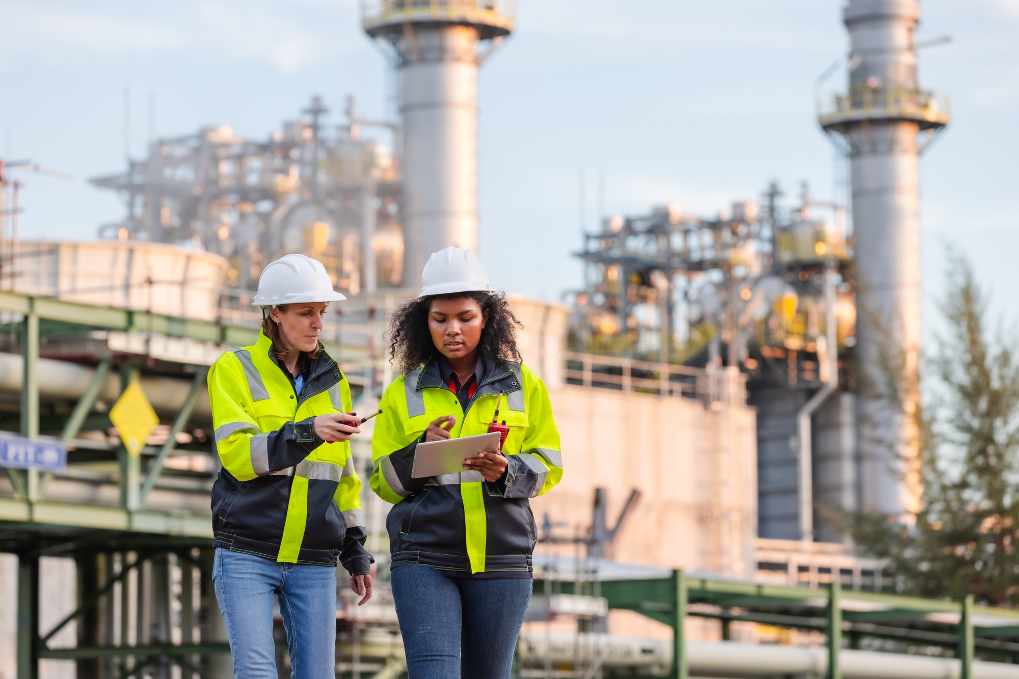 inspection at an industrial plant with refinery structures in the background