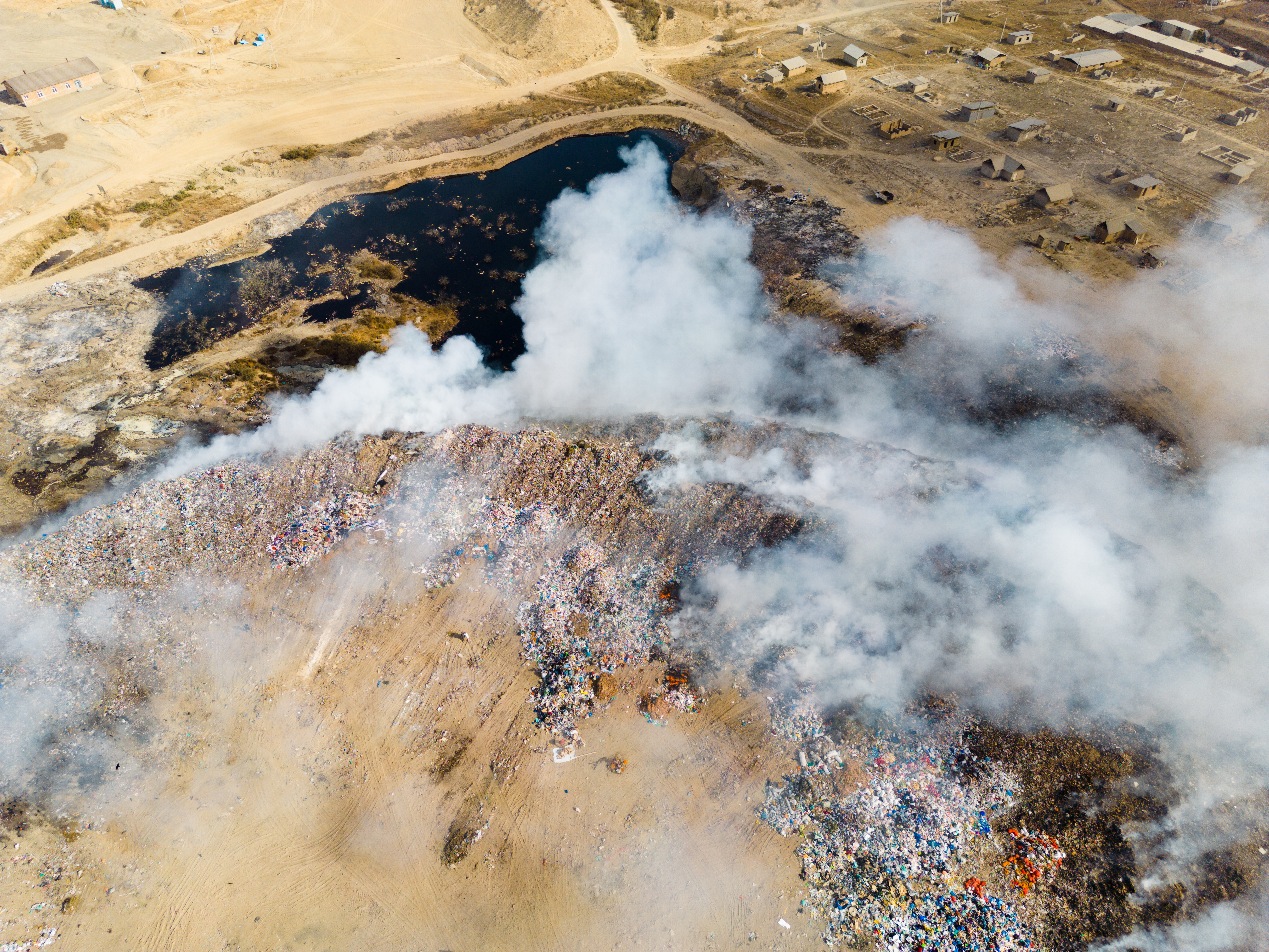 Aerial view of landfill with burning trash piles and toxic pond with contamination, landfill leachate, landfill leachate treatment, membranes